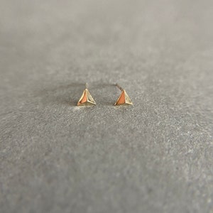 K&ouml;nnte beinhalten: Ein Paar goldene Dreiecks-Ohrstecker. Die Ohrringe sind klein und zart und haben ein schlichtes, modernes Design.