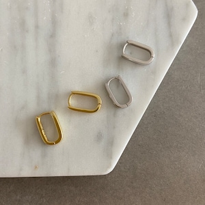 May include: Four pairs of hoop earrings in different sizes. Two pairs are gold, and two pairs are silver.