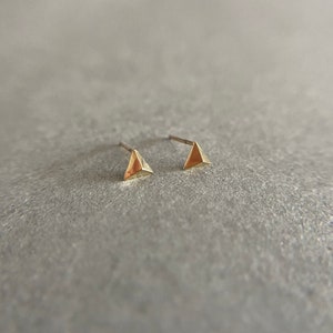 K&ouml;nnte beinhalten: Ein Paar goldene Dreiecks-Ohrstecker. Die Ohrringe sind klein und schlicht und w&uuml;rden eine gro&szlig;artige Erg&auml;nzung f&uuml;r jede Schmucksammlung sein.