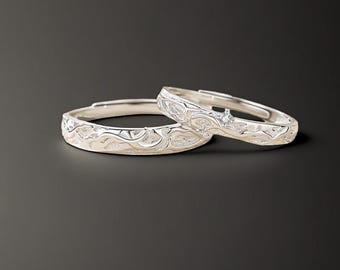 May include: Two silver rings with intricate designs. The rings are stacked on top of each other.