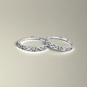 Peut inclure: Deux alliances en argent avec un motif de symbole infini et un petit accent diamant.