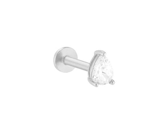May include: A silver body piercing with a clear pear-shaped gemstone.