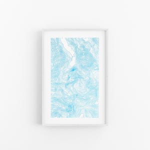 Può includere: Una stampa incorniciata rettangolare verticale con un design di mappa topografica azzurra. L'opera mostra linee di contorno complesse e fluide in varie tonalità di blu su uno sfondo bianco, racchiusa in una semplice cornice bianca.
