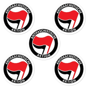 May include: Five black and white circular stickers with the text "Antifaschistische Aktion" in German. Each sticker features a red flag with a black fist in the center.