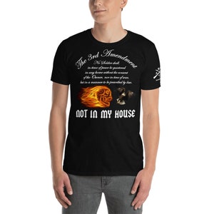 May include: Black t-shirt with white text that reads "The 3rd Amendment No Soldier shall in time of peace be quartered in any home without the consent of the Owner, nor in time of war, but in a manner to be prescribed by law. NOT IN MY HOUSE". The shirt features a graphic of a skull engulfed in flames and an eagle.