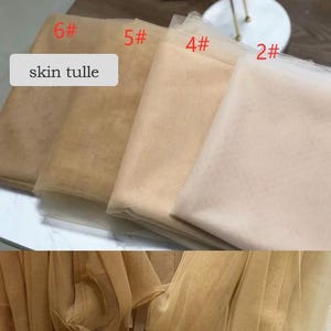 May include: A selection of skin-toned tulle fabric in various shades, labeled with numbers. The fabric ranges from light beige to darker tan, with the text "skin tulle" displayed on a white rectangle.