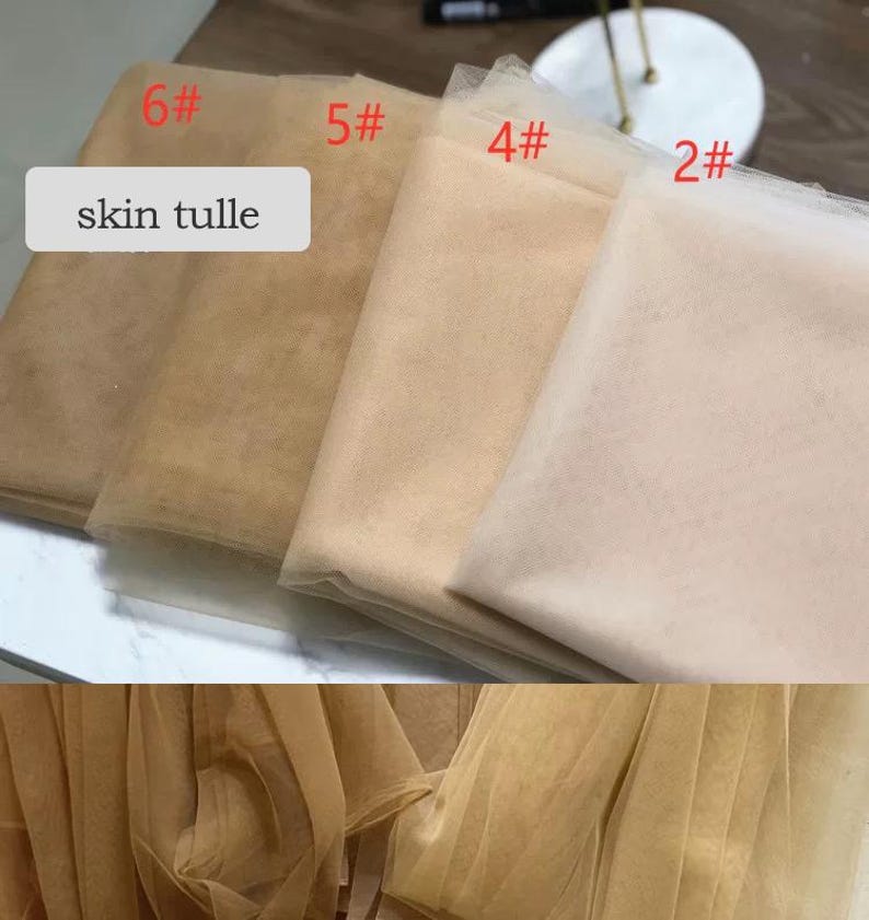 May include: A selection of skin-toned tulle fabric in various shades, labeled with numbers. The fabric ranges from light beige to darker tan, with the text "skin tulle" displayed on a white rectangle.