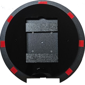 May include: Black round disc with a rectangular cutout in the center. The disc has red adhesive squares around the edge.