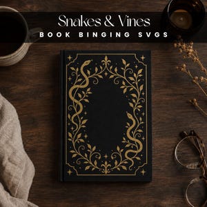 Può includere: Un libro con copertina rigida nera caratterizzato da un design in lamina color oro sulla copertina anteriore. Il disegno raffigura due serpenti intrecciati con viticci e piccole stelle, che formano una cornice ovale. Il testo "Snakes & Vines BOOK BINGING SVGS" è visibile.