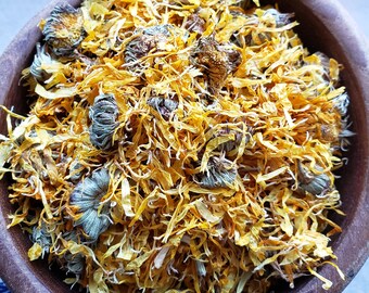 May include: A wooden bowl filled with dried calendula petals and buds. The petals are a bright yellow color and the buds are a greenish-brown color.