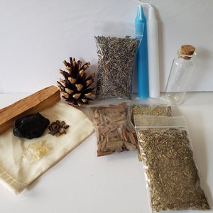 May include: A collection of items for a cleansing ritual, including a white candle, a small bottle, a pine cone, a bag of lavender, a bag of herbs, a bag of cinnamon sticks, a bag of dried herbs, a piece of palo santo wood, a black stone, and a small bag of crystals.