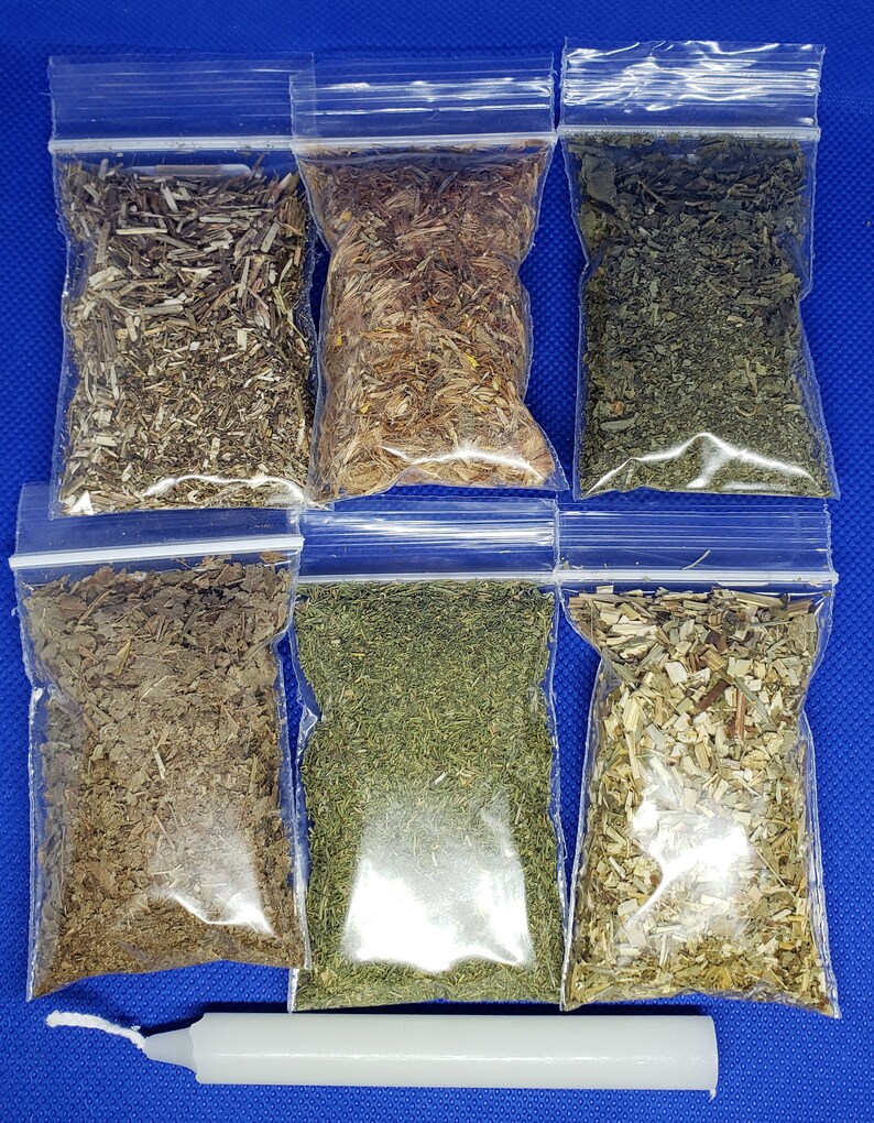 May include: Six small, clear plastic bags filled with dried herbs, arranged in two rows of three. The herbs vary in color, from light green to brown. A white candle rests at the bottom. The background is a solid blue.