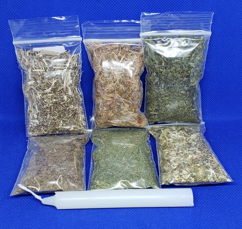 May include: Assortment of dried herbs in clear plastic bags, with a white candle on a blue background. The herbs vary in color, including green, brown, and tan. The bags are sealed with a zip closure.