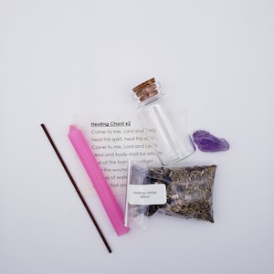 May include: A pink candle, a brown incense stick, a small glass bottle with a cork stopper, a small bag of dried herbs labeled "Healing Herbal Blend", and a purple amethyst crystal on a white background. The text on the card reads "Healing Chant x2 Come to me, Lord and Lady Heal this spirit, heal this sc Come to me, Lord and Lac Mind and body shall be whove st of the burr light this wounc ss of wate fast an"
