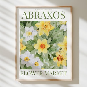 Puede incluir: L&aacute;mina art&iacute;stica enmarcada con narcisos amarillos y blancos sobre un fondo verde. La impresi&oacute;n incluye el texto "ABRAXOS" y "FLOWER MARKET" en una fuente serif, con "THE FRESHEST FLOWERS IN TOWN" arriba.