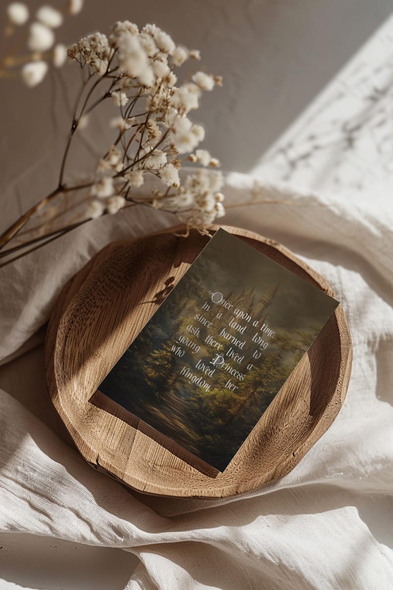 May include: A wooden tray holds a card with the text "Once upon a time..." against a forest and castle backdrop. White flowers and soft fabric surround the tray, creating a fairytale theme.