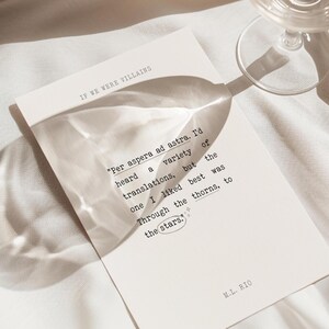 May include: A white card with a quote printed in black text. The quote reads "Per aspera ad astra. I'd heard a variety of translations, but the one I liked best was Through the thorns, to the stars." The card also includes the text "IF WE WERE VILLAINS" and "M.L. RIO".