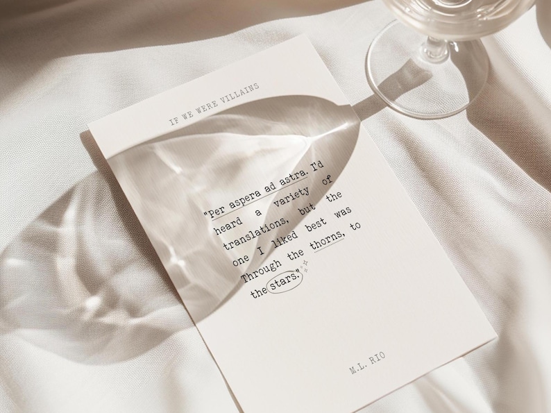 May include: A white card with a quote printed in black text. The quote reads "Per aspera ad astra. I'd heard a variety of translations, but the one I liked best was Through the thorns, to the stars." The card also includes the text "IF WE WERE VILLAINS" and "M.L. RIO".