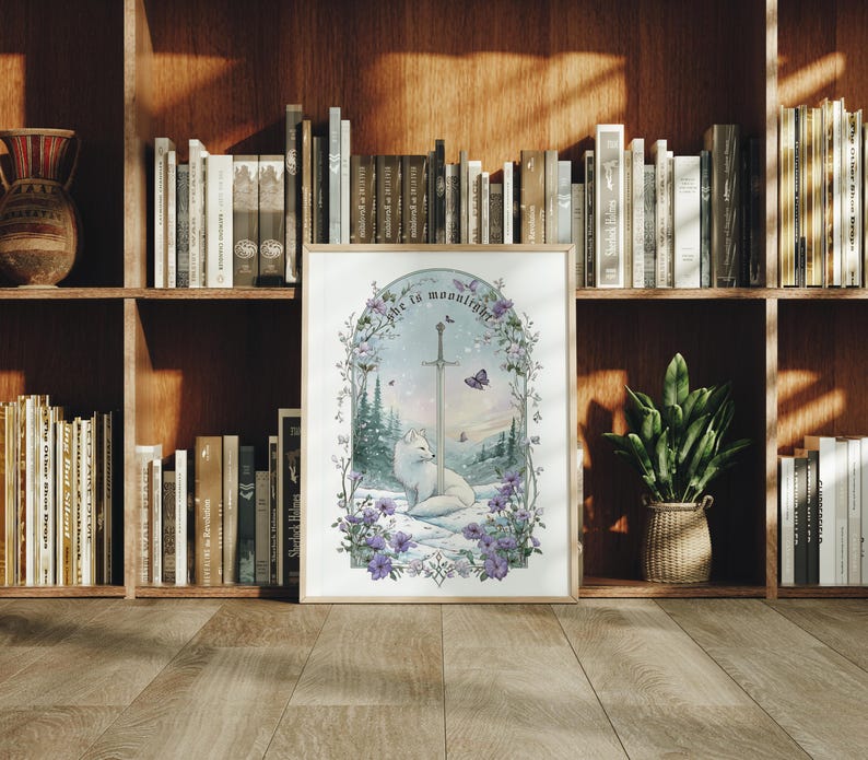 Puede incluir: Una impresi&oacute;n art&iacute;stica enmarcada que presenta un zorro blanco sentado en un paisaje nevado con una espada y el texto "she is moonlight". La obra de arte est&aacute; rodeada de flores moradas y mariposas, sobre un fondo de bosque.