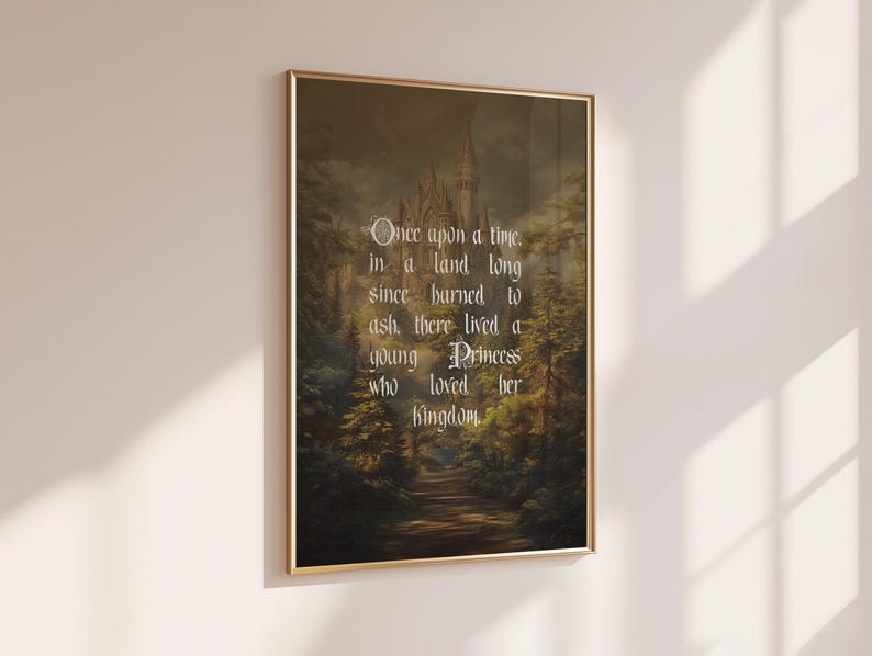 May include: A framed print with a gold border, featuring a fairytale scene of a castle in a forest. The text reads, "Once upon a time, in a land long since burned to ash, there lived a young Princess who loved her Kingdom."