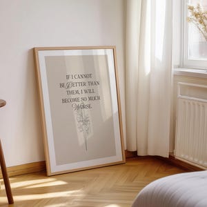 May include: A framed print with a light brown background and a wooden frame. The print features the quote, "If I cannot be better than them, I will become so much worse." The text is in black, with a floral illustration below.