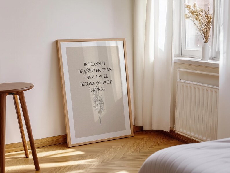 May include: A framed print with a light brown background and a wooden frame. The print features the quote, "If I cannot be better than them, I will become so much worse." The text is in black, with a floral illustration below.