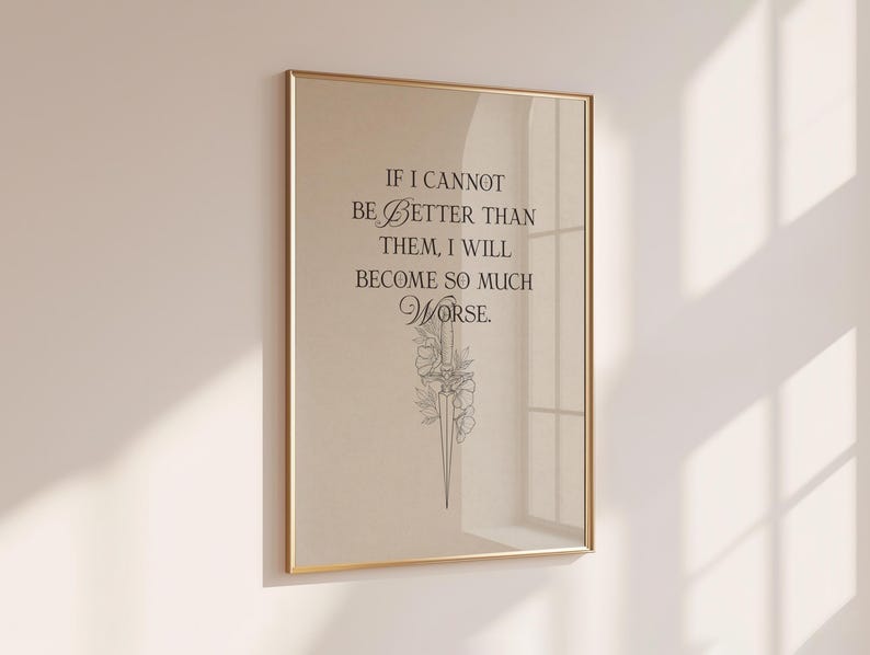 May include: A framed print with a gold-coloured frame. The print features the quote, "IF I CANNOT BE BETTER THAN THEM, I WILL BECOME SO MUCH WORSE." Below the text is a delicate floral illustration in black.