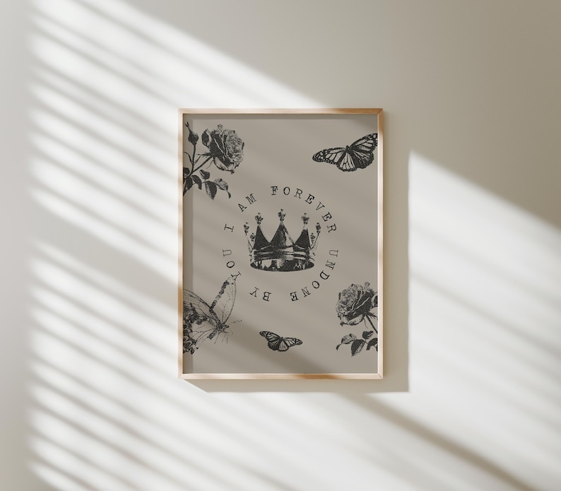 May include: Framed art print featuring a beige background with black illustrations. The design includes a crown, butterflies, and roses. Text within a circle reads "I AM FOREVER UNDONE BY YOU."