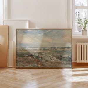 Op de afbeelding: Een ingelijste landschapskunstafdruk met een vintage esthetiek. Het kunstwerk heeft een gedempt kleurenpalet van blauw, bruin en cr&egrave;me, dat een kustsc&egrave;ne uitbeeldt. De tekst "Keep reaching out your hand" staat over de afbeelding geschreven.