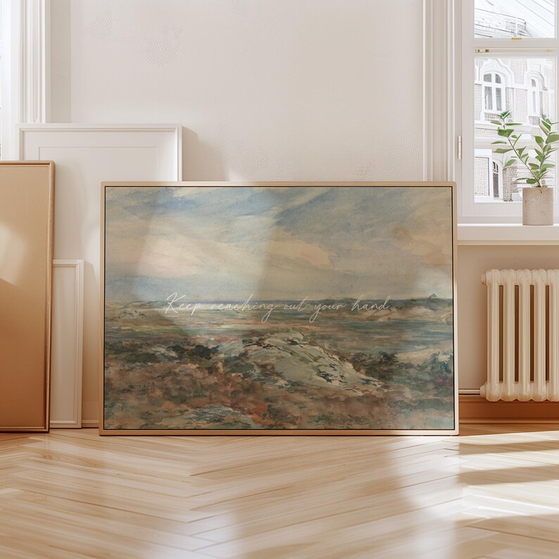 Op de afbeelding: Een ingelijste landschapskunstafdruk met een vintage esthetiek. Het kunstwerk heeft een gedempt kleurenpalet van blauw, bruin en cr&egrave;me, dat een kustsc&egrave;ne uitbeeldt. De tekst "Keep reaching out your hand" staat over de afbeelding geschreven.