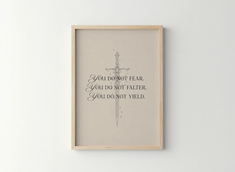 Może przedstawiać: Oprawiony wydruk z jasnobeżowym tłem i drewnianą ramą. Grafika przedstawia szczeg&oacute;łowy czarny rysunek linii miecza oraz tekst "You do not fear. You do not falter. You do not yield."