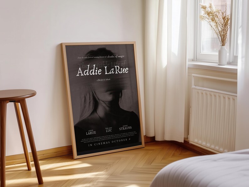 K&ouml;nnte beinhalten: Ein Filmplakat f&uuml;r den Film "The Remarkable Life of Addie LaRue", Regie: Diane English. Das Plakat zeigt ein Schwarzwei&szlig;bild eines Frauen Gesichts mit dem Titel des Films in wei&szlig;er Schrift. Das Plakat enth&auml;lt auch die Namen der Schauspieler und das Erscheinungsdatum.