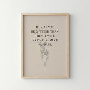 May include: A framed print featuring the quote "IF I CANNOT BE BETTER THAN THEM, I WILL BECOME SO MUCH WORSE." The artwork has a beige background, black text, and a floral and sword illustration. The frame is light brown.