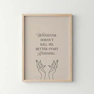 May include: Framed art print with a light beige background and a wooden frame. The print features the quote "Whatever doesn't kill me, better start running" in elegant script, with a line drawing of hands at the bottom.