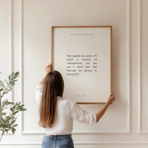 May include: A framed print with a white background and black text. The text reads "Per aspera ad astra. I'd heard a variety of translations, but the one I liked best was Through the thorns, to the stars." The text is attributed to W.B.  Yeats.