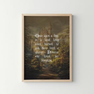 May include: Framed art print featuring a fairytale scene with a castle, trees, and a path. The text reads "Once upon a time, in a land long since burned to ash, there lived a young Princess who loved her kingdom."