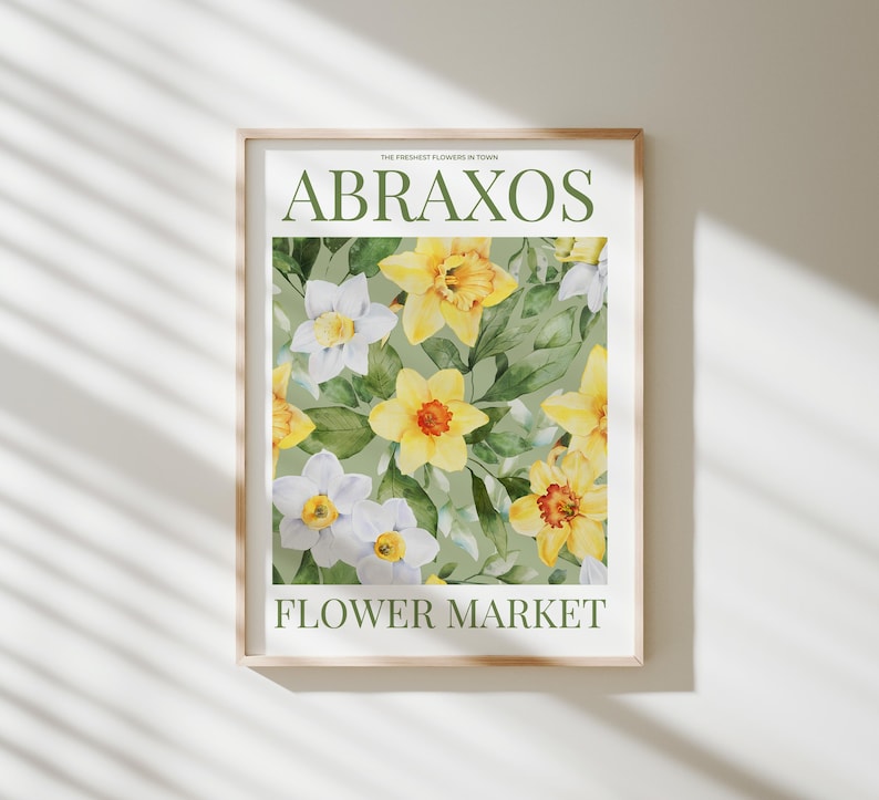Puede incluir: L&aacute;mina art&iacute;stica enmarcada con narcisos amarillos y blancos sobre un fondo verde. La impresi&oacute;n incluye el texto "ABRAXOS" y "FLOWER MARKET" en una fuente serif, con "THE FRESHEST FLOWERS IN TOWN" arriba.