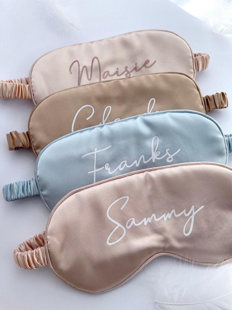 May include: Four satin sleep masks in different colors with personalized names embroidered in white: Maisie, Chloe, Franks, and Sammy.