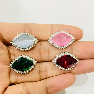 Peut inclure: Quatre embellissements décoratifs en forme de diamant avec un sertissage argenté et des accents de cristal transparent. Les embellissements sont de couleur blanche, rose, verte et rouge.