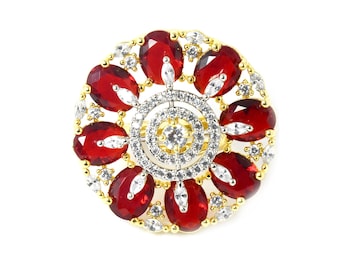Könnte beinhalten: Ein goldener Ring mit einem runden Design, das mit roten und weißen Steinen besetzt ist. Der Ring hat einen zentralen Kreis aus weißen Steinen, der von einem Ring aus roten Steinen umgeben ist.