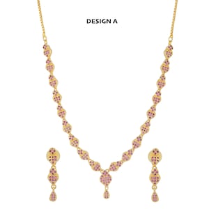 May include: Gold necklace and earrings set with pink gemstone accents. The necklace features a teardrop pendant and the earrings are drop style. DESIGN A.