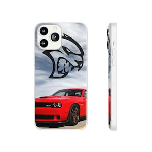 May include: A white phone case with a red Dodge Challenger SRT Hellcat and a black Dodge logo. The phone case is designed for an iPhone with a camera bump.
