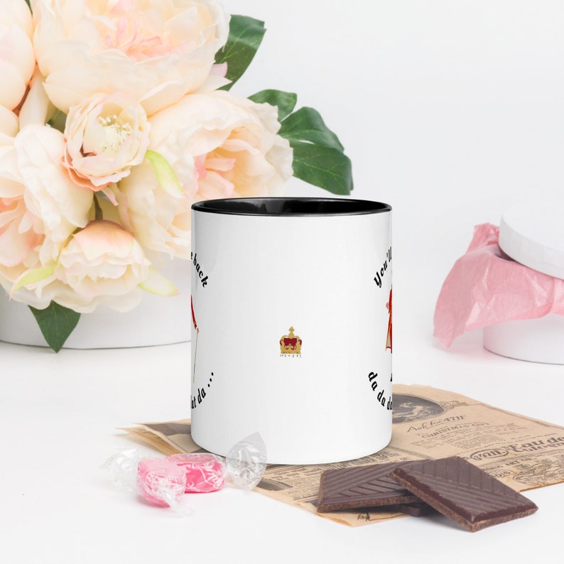 May include: White ceramic mug with a black rim. The mug has a black and red illustration of a person wearing a crown and the text "You'll never get da... da da da... back".