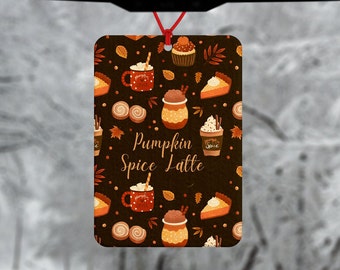 May include: A brown car air freshener with a pattern of pumpkin spice lattes, cupcakes, and pie slices. The text "Pumpkin Spice Latte" is in the center of the air freshener.