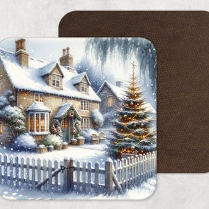 May include: Square coaster depicting a winter scene of a snow-covered cottage with a Christmas tree. The cottage has a white picket fence and a wreath on the door. The second coaster is brown.