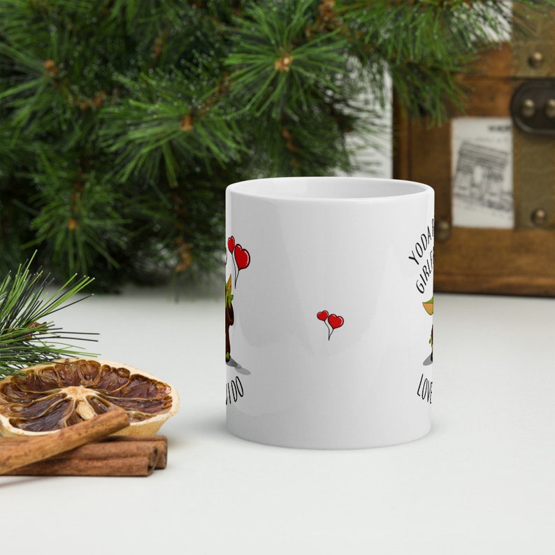 May include: White ceramic mug with a green and brown cartoon character holding red balloons. The text "Yoda Girl, I Love You" is printed on the mug.