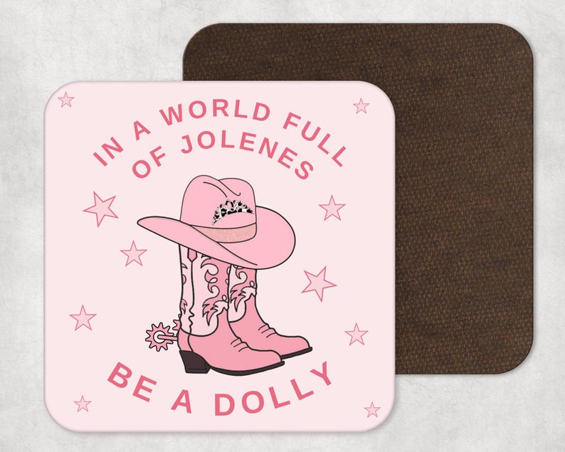 Pode incluir: Copo de apoio rosa e branco com o texto "Em um mundo cheio de Jolenes, seja uma Dolly". O copo de apoio apresenta um chap&eacute;u de caub&oacute;i rosa e um par de botas de caub&oacute;i rosas com um padr&atilde;o de estrelas brancas.