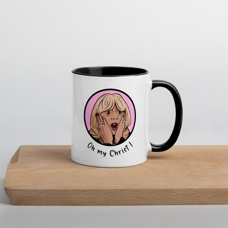 May include: White ceramic mug with a black interior and handle. The mug features a cartoon illustration of a surprised woman with the text "Oh my Christ!" in black. The design is set in a pink circle.