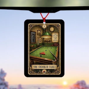 May include: A rectangular hanging air freshener featuring a tarot card style illustration of a snooker table. The image shows a green table with balls, a cue, and a scoreboard. Text reads: TAKE YOUR TIME THINK AIM ENJOY and THE SNOOKER TABLE.