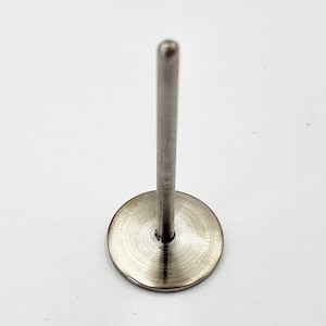 May include: A silver metal push pin with a round base and a long, thin shaft.
